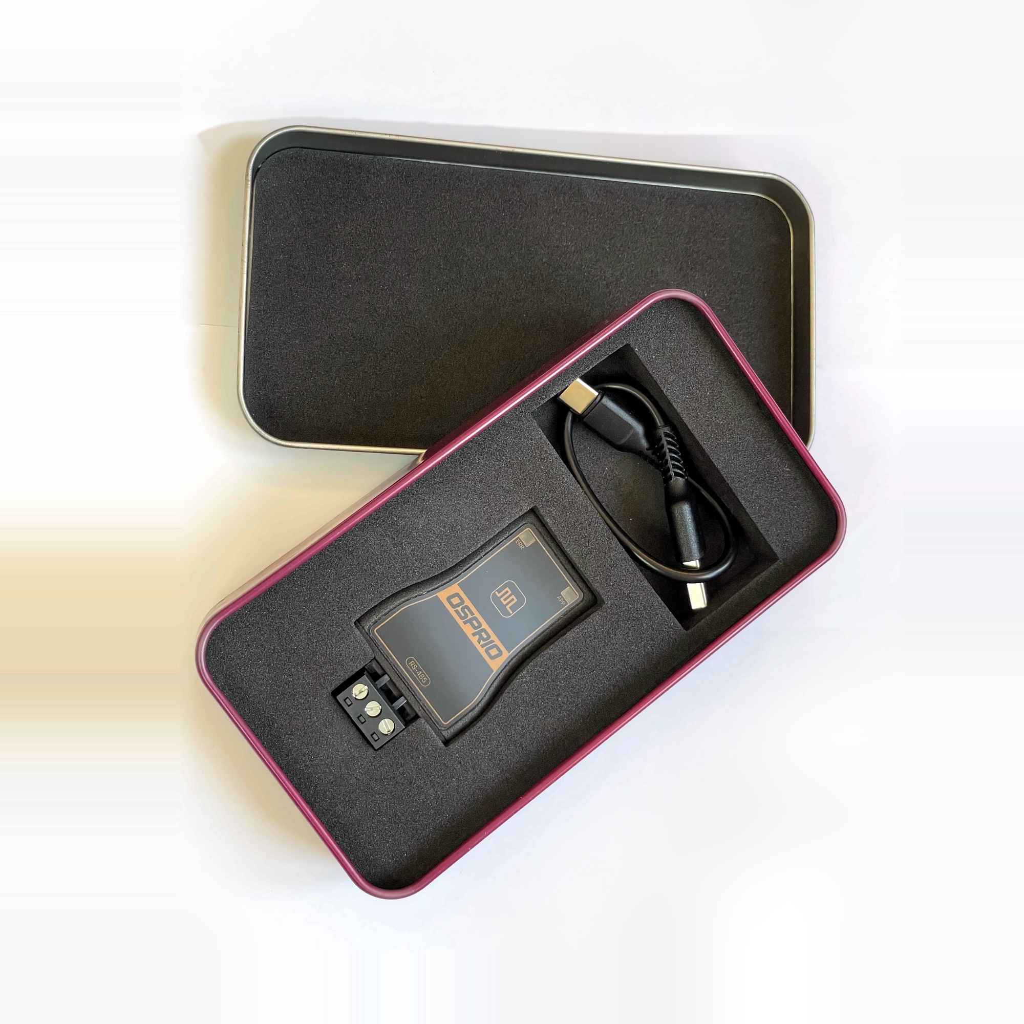 Osprio Mini and its USB-C cable in the shipping tin, lid alongside